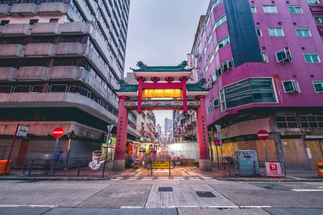 Vibrant entrance to Kowloon street market in Hong Kong, captured at dusk, showcasing urban life.