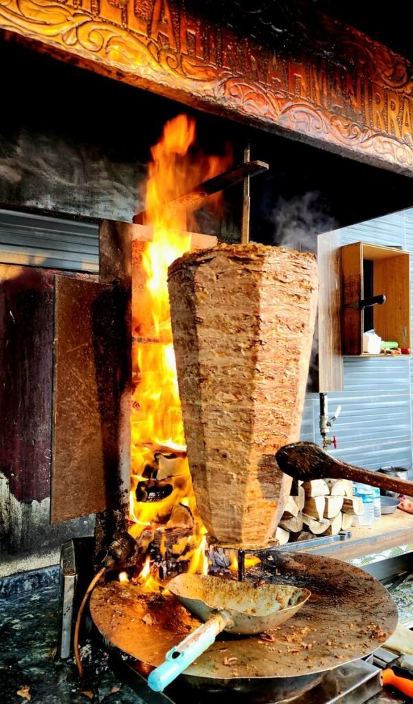 A vibrant shot of a traditional Turkish döner kebab being cooked on an open flame in Samsun, Türkiye.