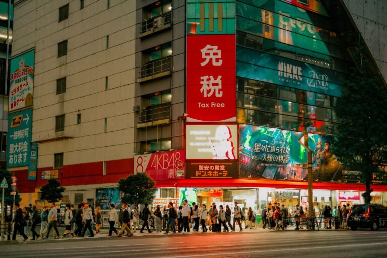 Vivid city lights illuminate bustling streets in Tokyo's Akihabara at night.