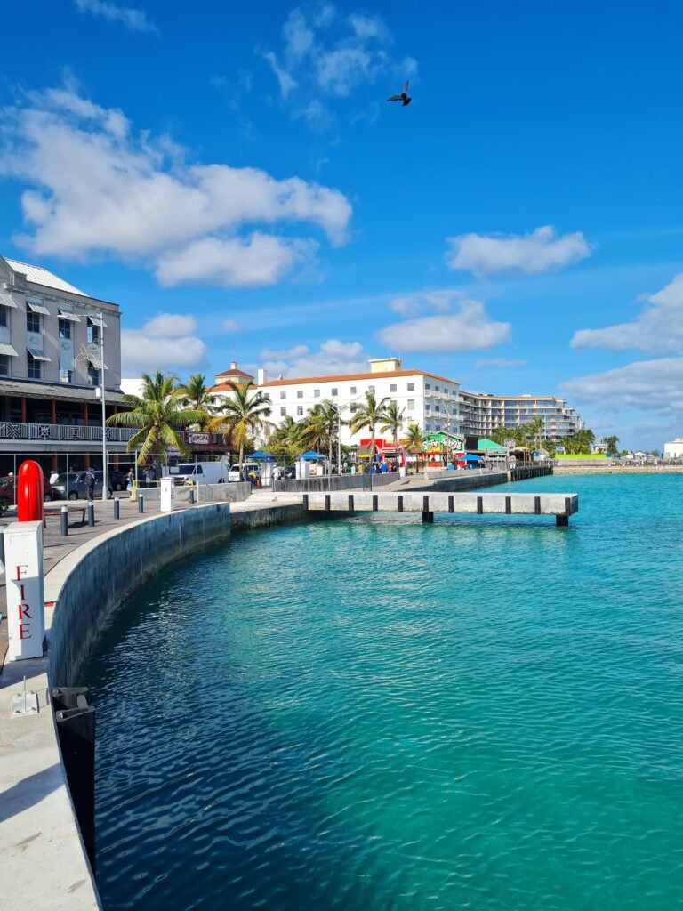 Beautiful view of Nassau harbor with clear blue waters and a vibrant skyline under a bright blue sky.